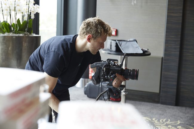 Janik Osthöver hinter ein Red Cinema Kamera bei der Aufnahme von einem Interview