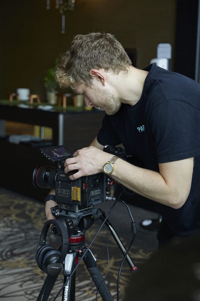 Janik Osthöver hinter ein Red Cinema Kamera bei der Aufnahme von einem Interview