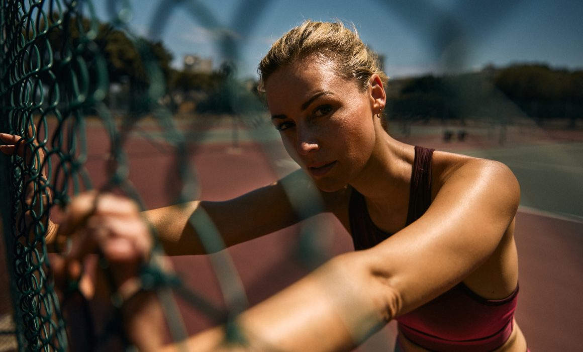 Junge Frau treibt Sport auf einem Tennisplatz in Kapstadt in Südafrika